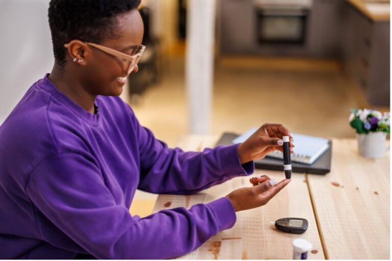 A cautious young woman is conducting a blood sugar test at home due to chronic diabetes caused by the intake of high fructose corn syrup